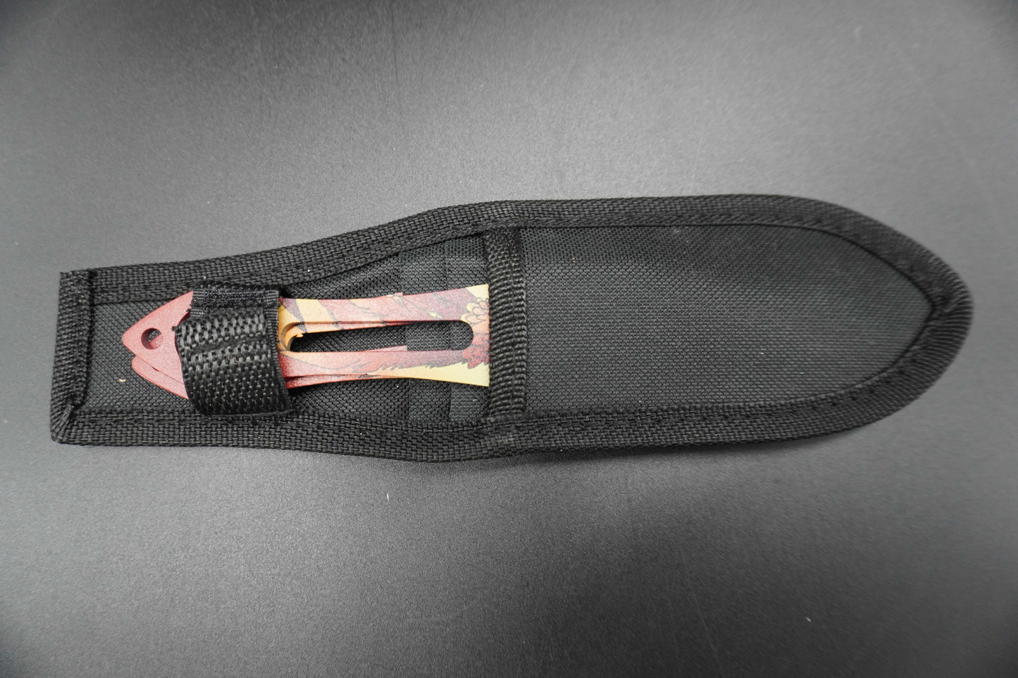 Black sheath with a metallic blade on a gray background