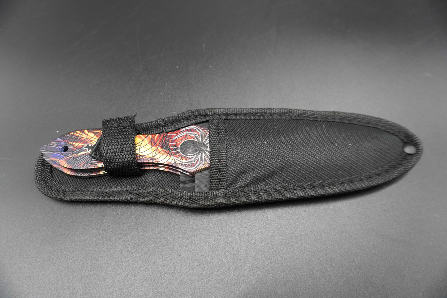 Black sheath with a colorful blade on a gray background