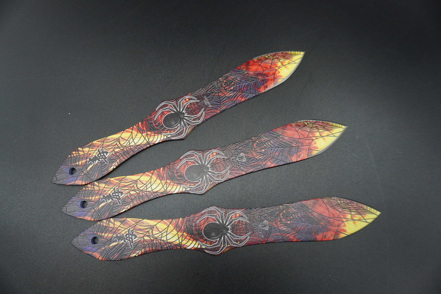 Three decorative paper blades with intricate patterns on a dark background