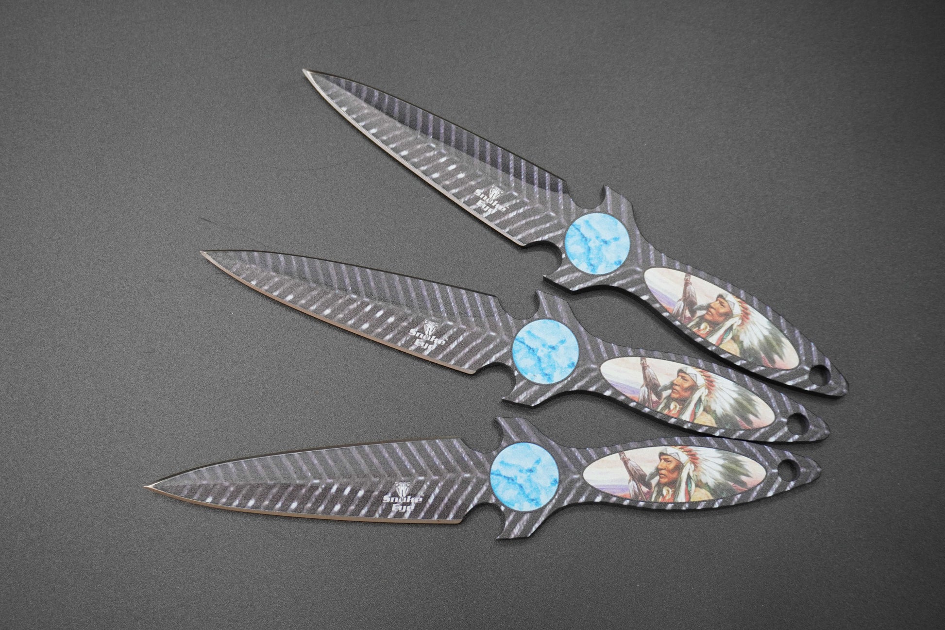 Four Decorative knives with gemstone handles on a gray background