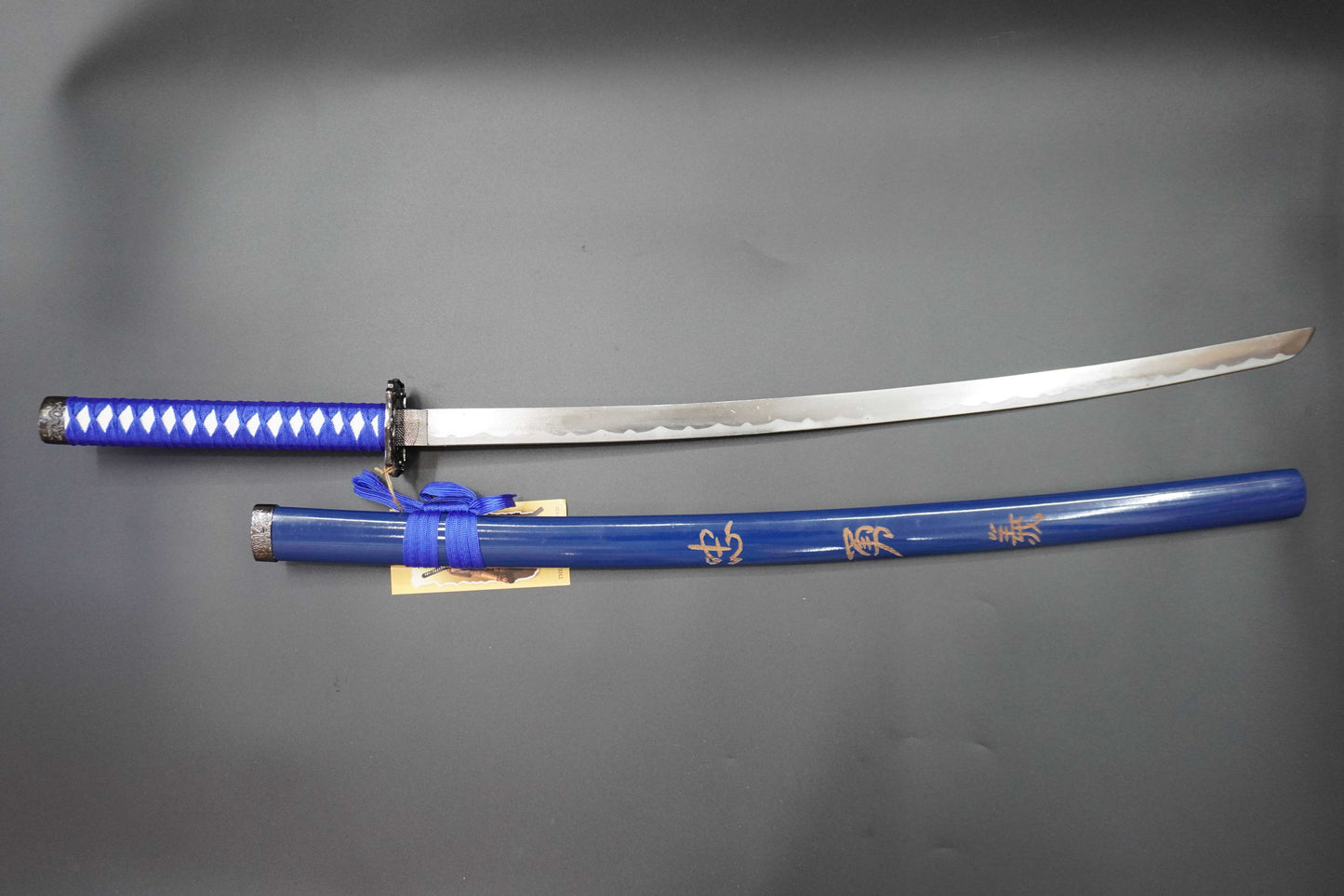 Sword with blue sheath on a gray background