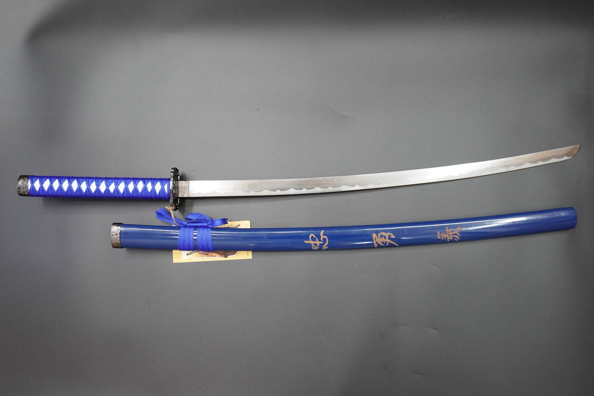 Sword with blue sheath on a gray background