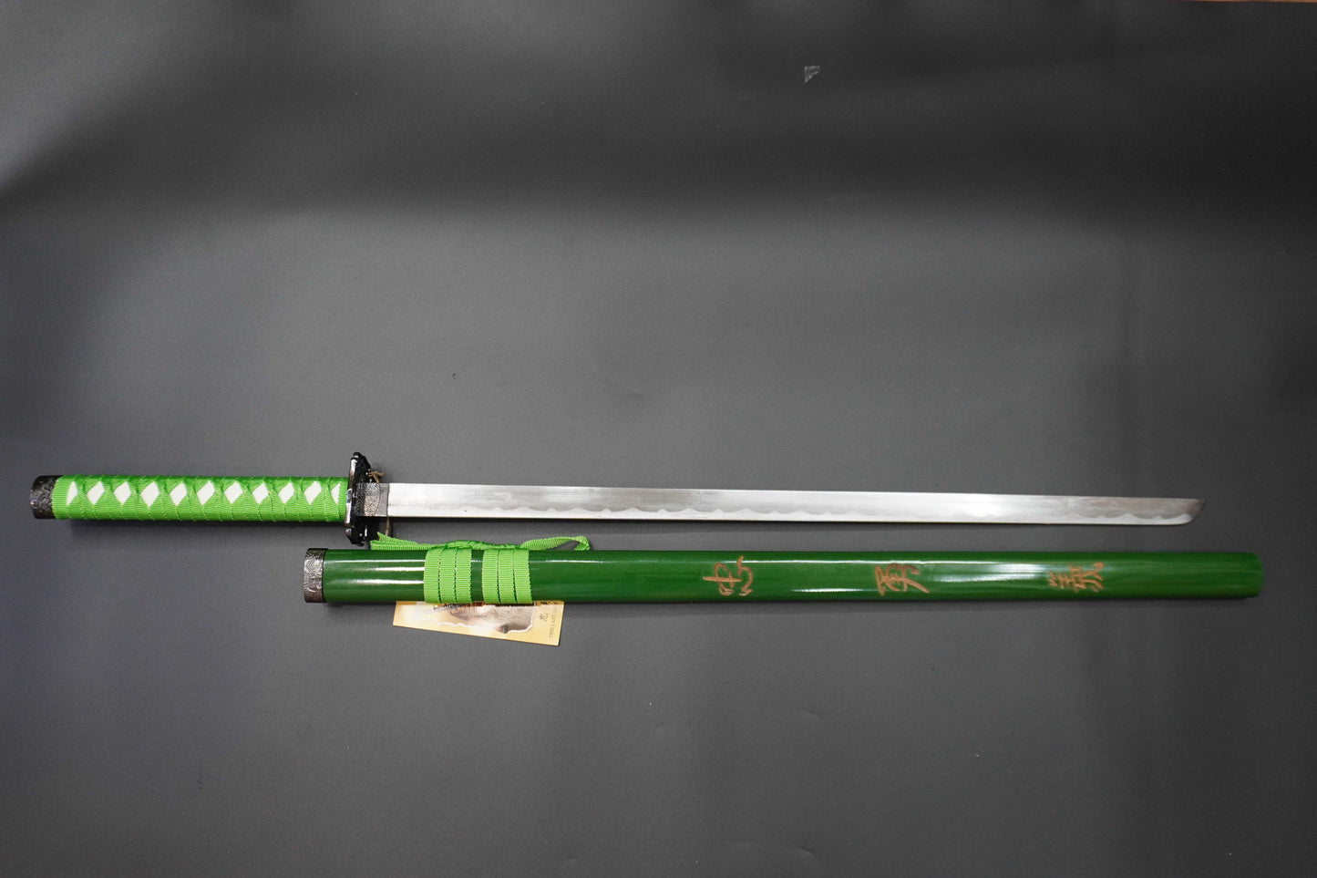 Green sword with a black handle on a gray background
