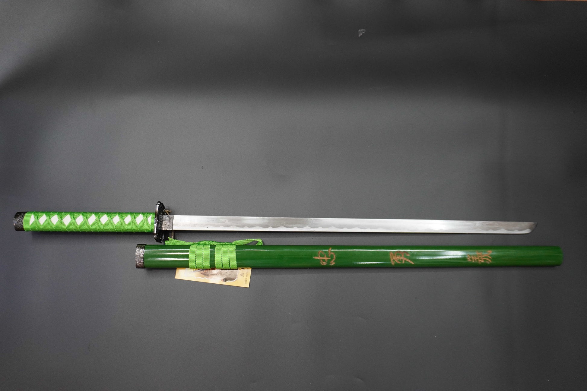 Green sword with a black handle on a gray background