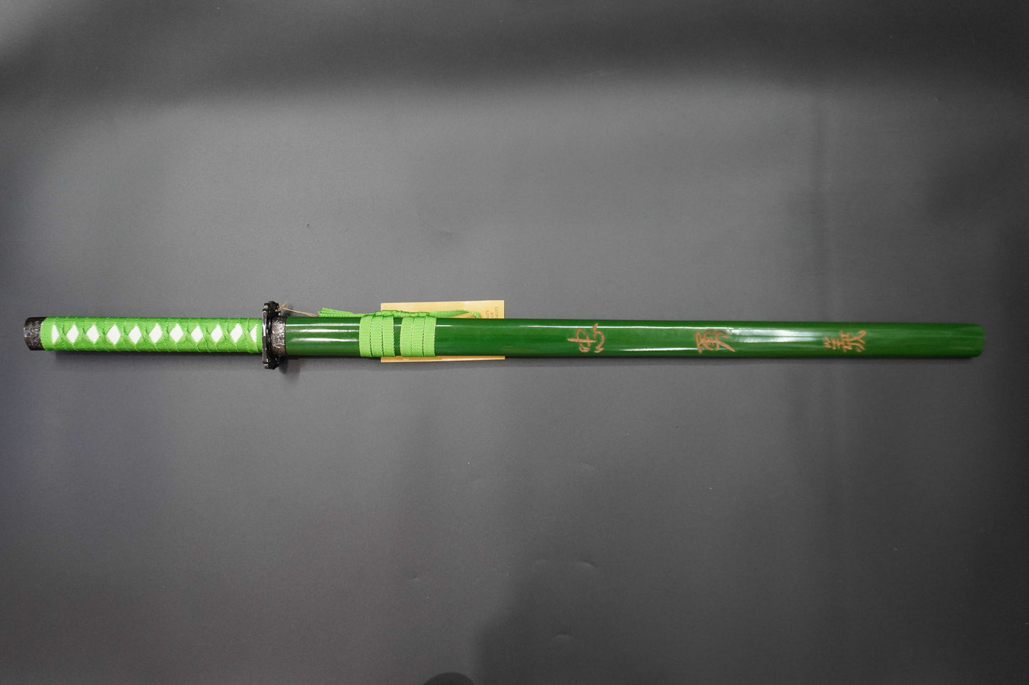 Green sword with decorative patterns on a gray background