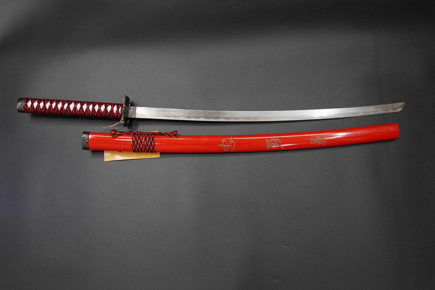 Sword with red sheath on a gray background