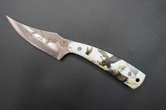 Folding knife with engraved handle on a dark gray background