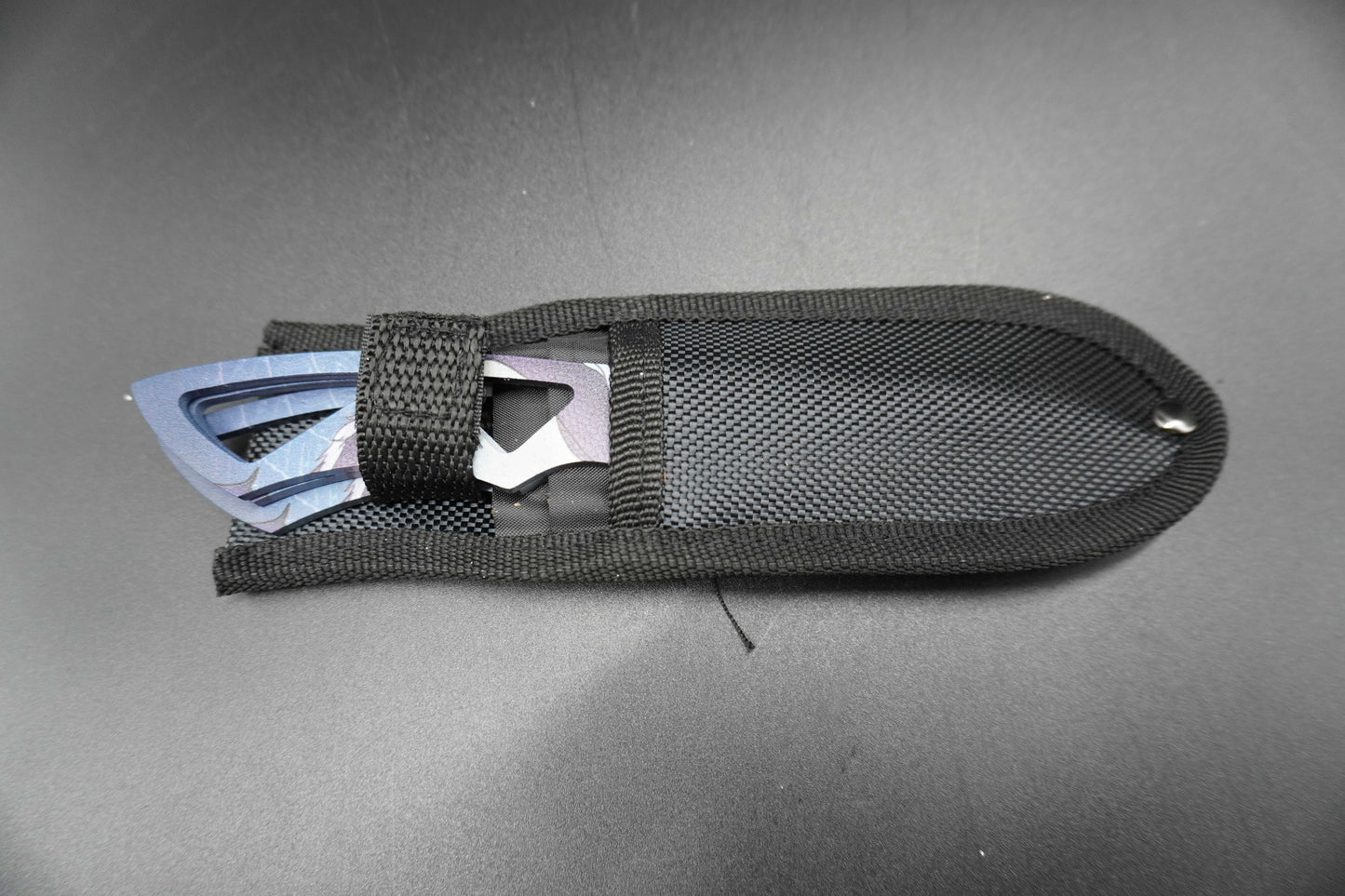 Black tool with metal components on a gray background