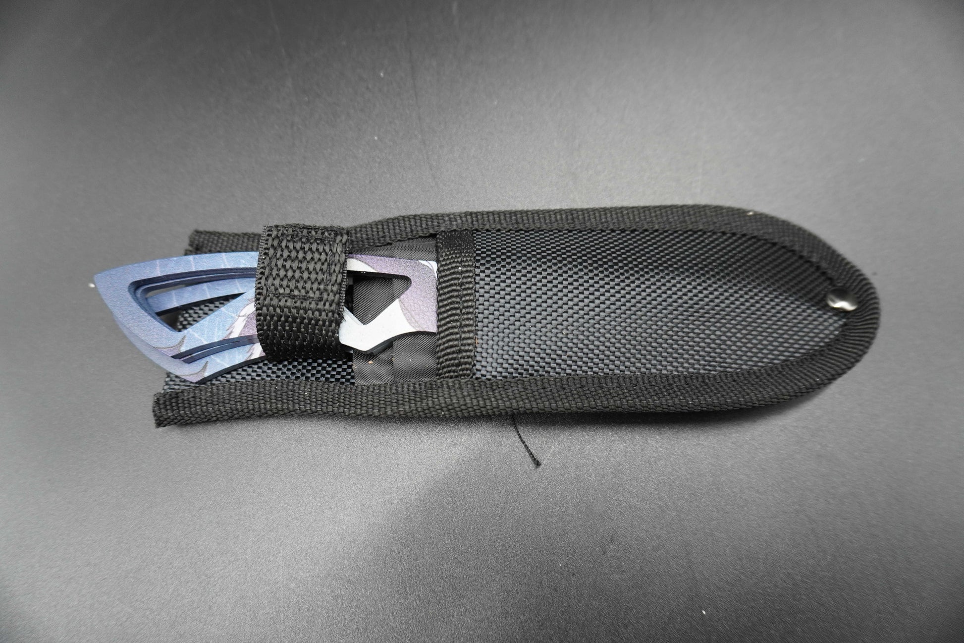 Black tool with metal components on a gray background