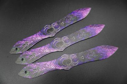 Three purple decorative items with intricate patterns on a dark surface